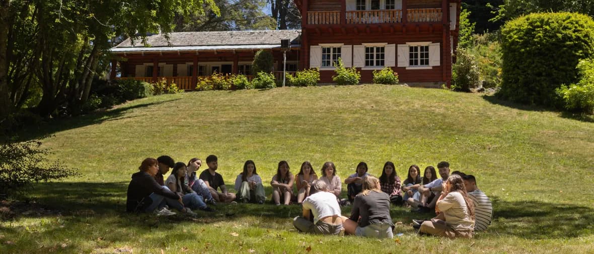 Grupo de jóvenes participantes reunidos en círculo sobre el césped