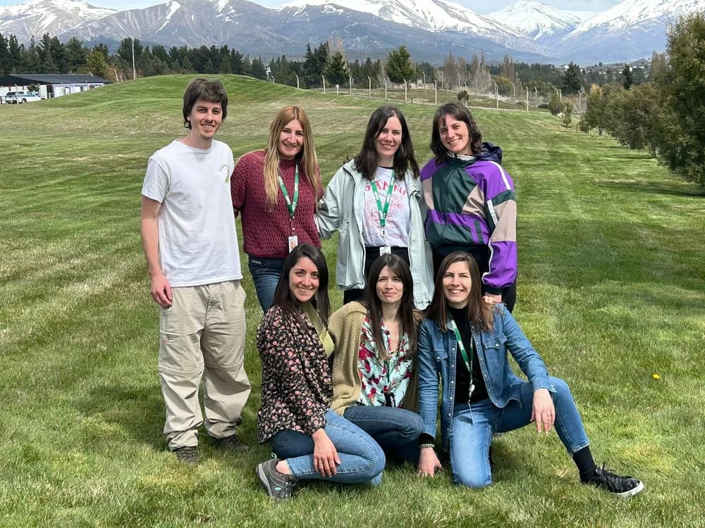 Equipo de la Fundación INVAP posando al aire libre con la cordillera de fondo