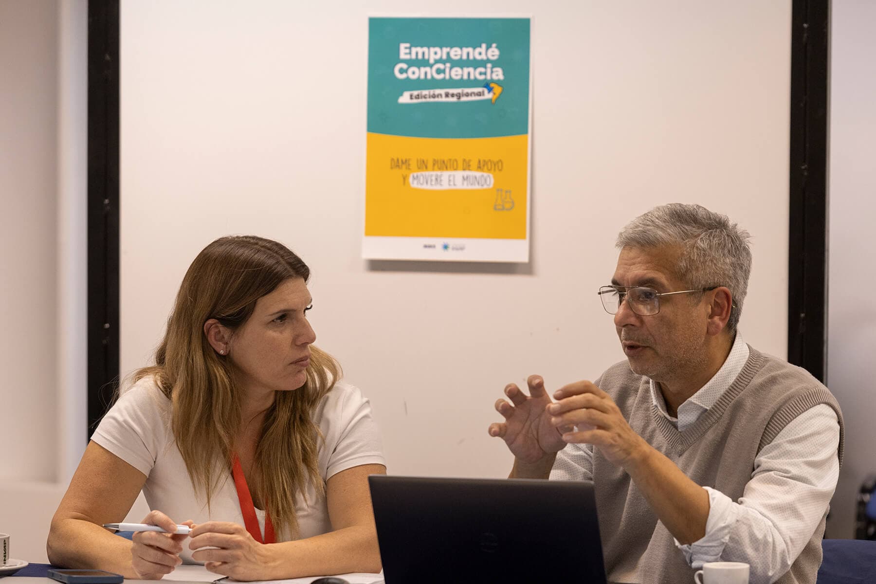 Dos personas conversando durante una reunión